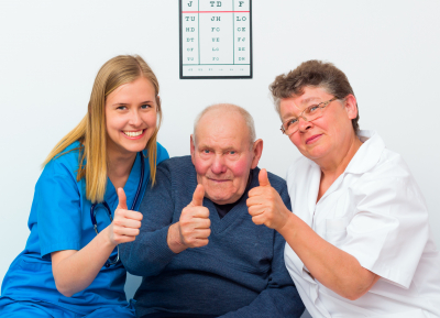 happy moments at the nursing home, elderly man showing thumbs up with his caregivers