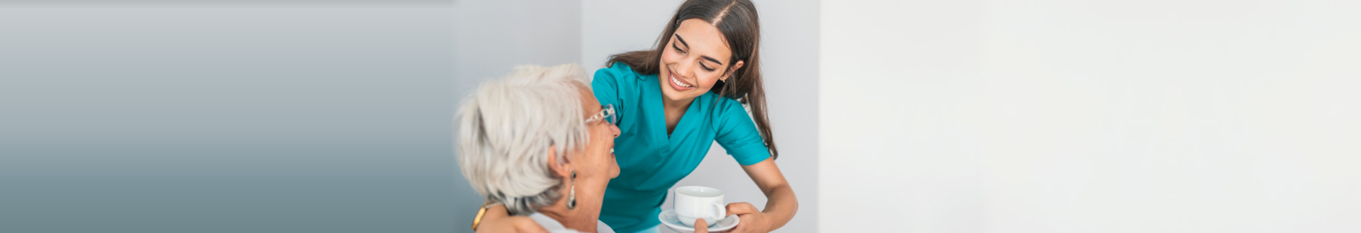 nurse giving cup of coffee to senior woman